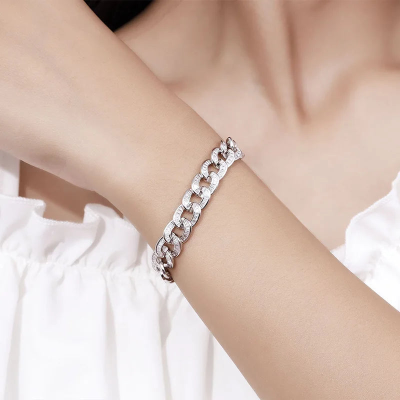 Silver chain bracelet on a person's wrist with a blurred background
