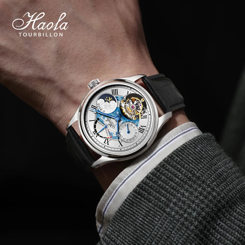 A close-up of a wrist wearing a Haola Tourbillon skeleton watch with a black leather strap, silver case, and a detailed blue and gold dial, shown against a dark background with the model's arm and clothing visible.