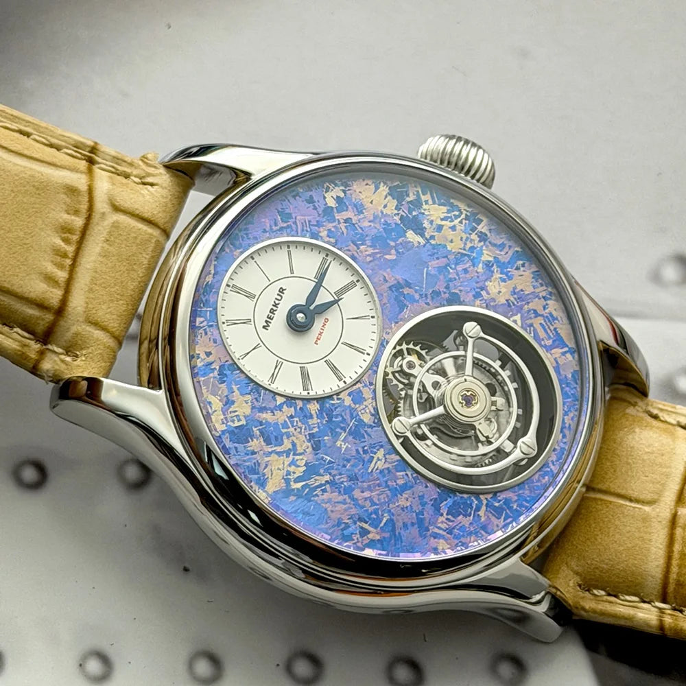 Luxury watch with a blue face and beige leather strap on a textured gray background