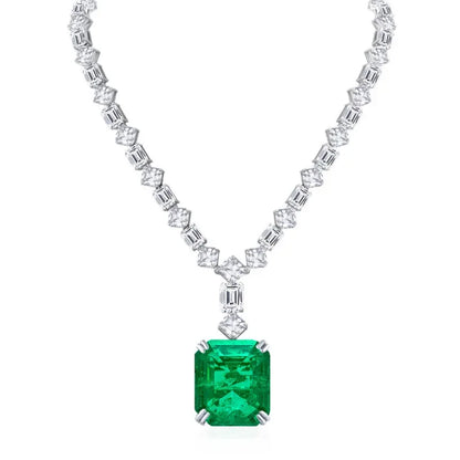 Diamond necklace with a central emerald stone on a white background