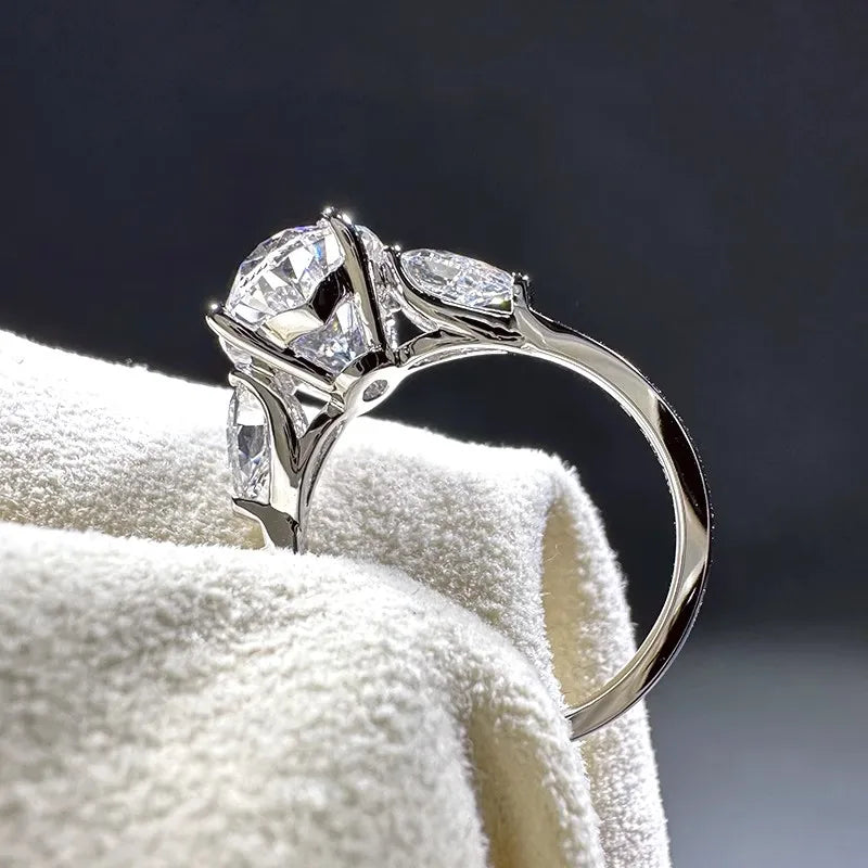 Silver ring with two large diamonds on a white towel against a dark background