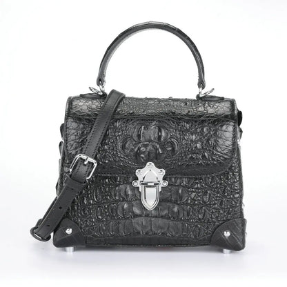 Black crocodile-embossed leather handbag with a top handle, shoulder strap, silver-tone clasp, and protective metal corner guards, shown on a white background.
