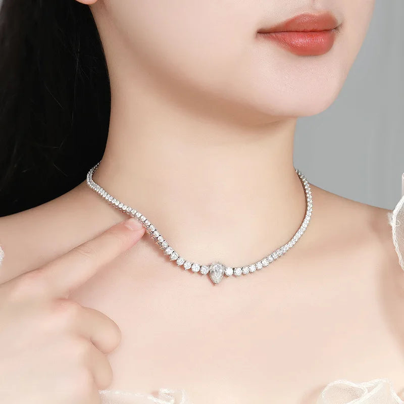 Close-up of a woman wearing a silver necklace with a heart pendant.