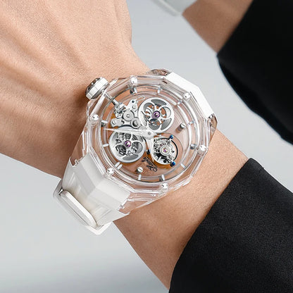 Watch with transparent case and white strap on wrist against a neutral background