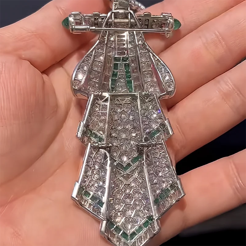 Silver pendant with gemstones held in a hand