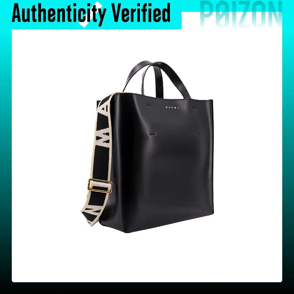 A black leather tote bag with double top handles and a wide black-and-white patterned shoulder strap with gold-tone hardware, shown on a white background with a teal border and 'Authenticity Verified' text at the top.