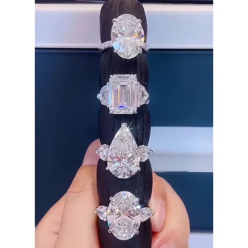 Set of diamond rings on a black stand held by a hand against a blurred background