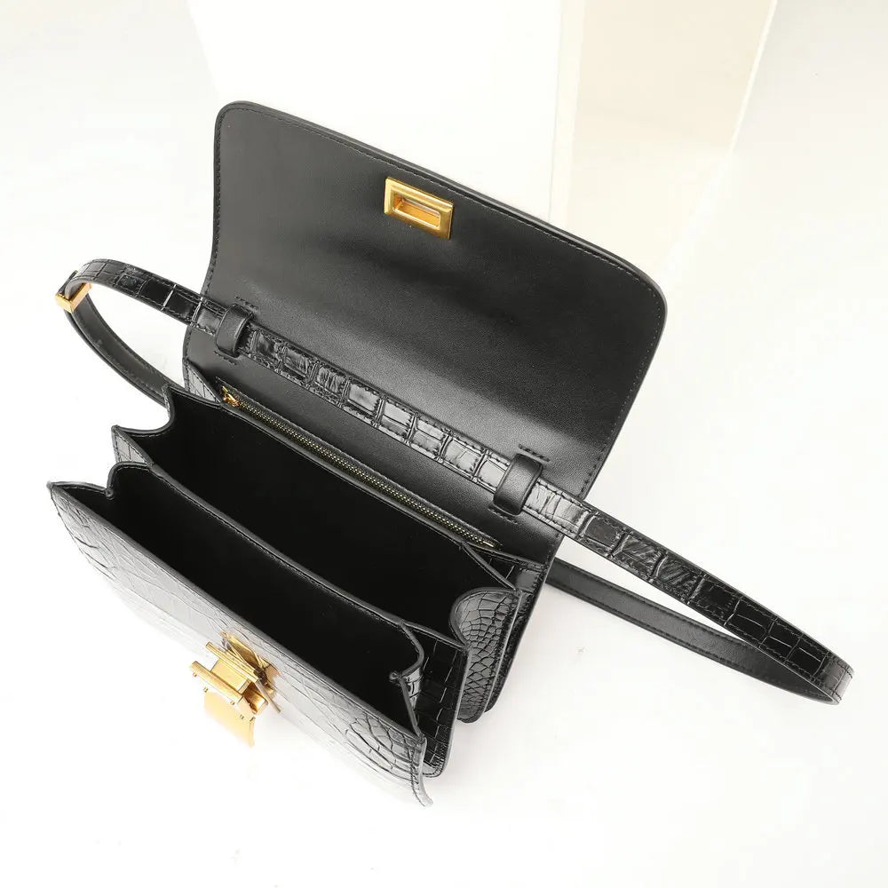 Black crocodile-embossed leather handbag shown open, featuring gold-tone hardware and a zippered interior, photographed on a clean white background.