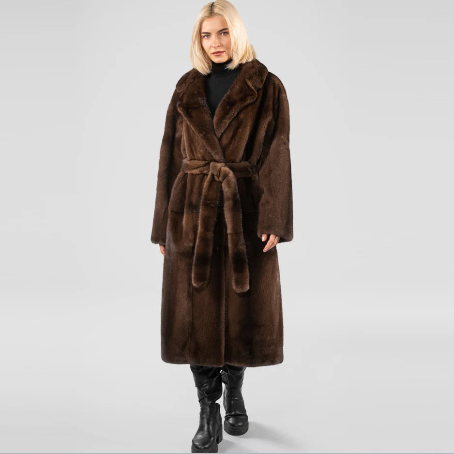 Woman wearing a brown fur coat on a light gray background