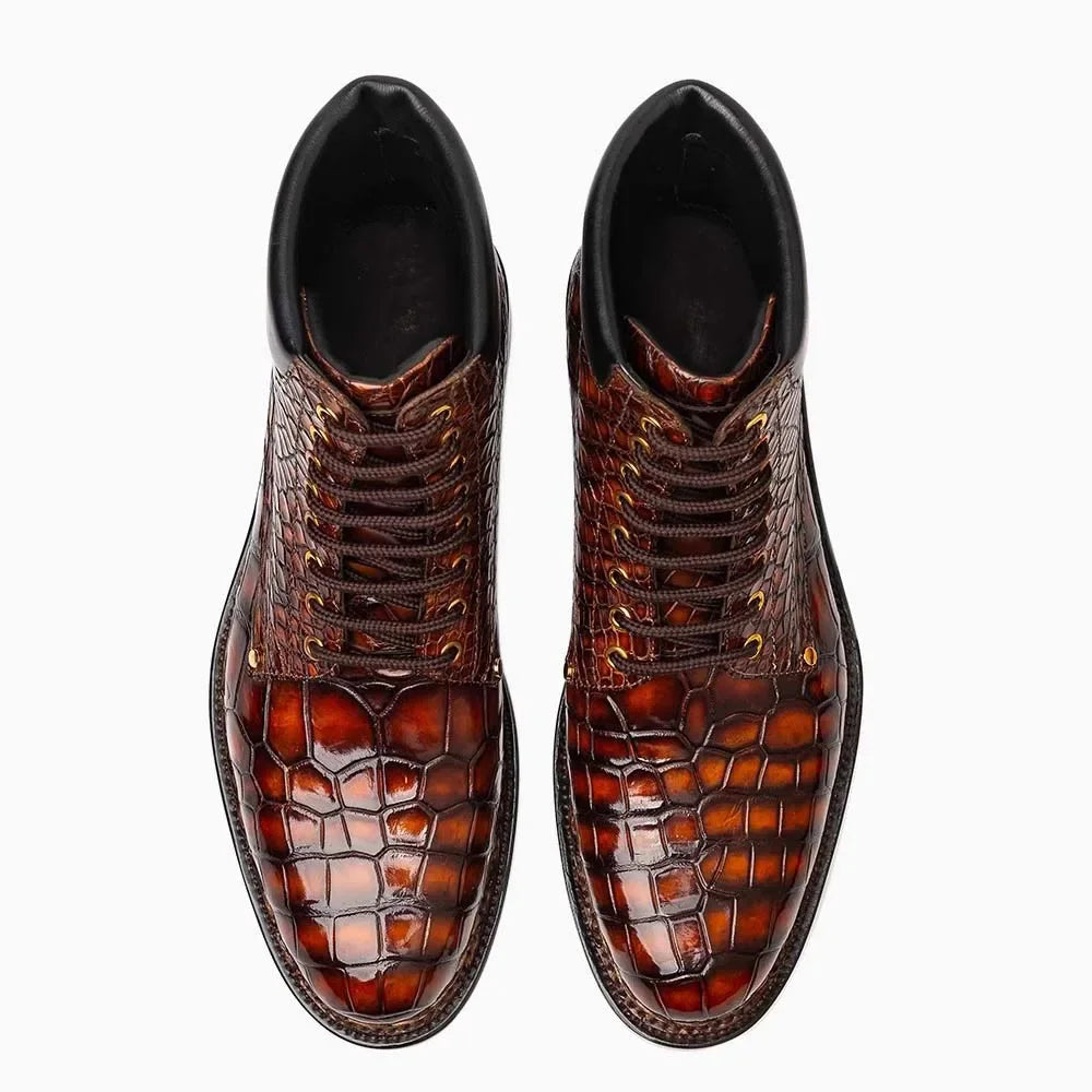 A pair of men's lace-up ankle boots featuring glossy brown crocodile-embossed leather on the toe and sides, with dark brown laces and black interiors, shown from a top-down view on a white background.