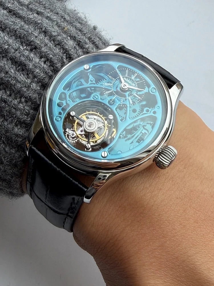 Sleek wristwatch with a black leather strap on a wrist, against a neutral background