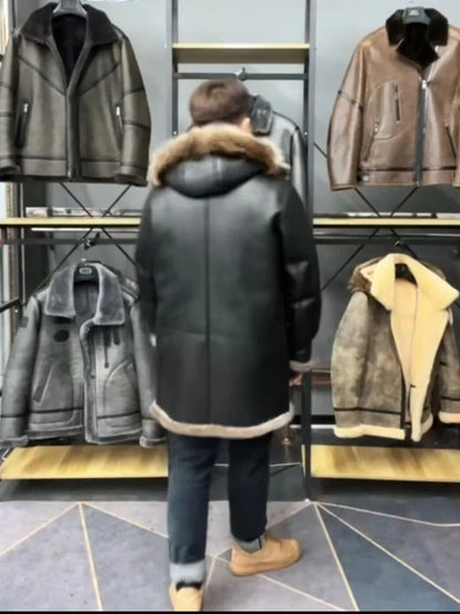 A person viewed from behind wearing a black shearling-lined hooded jacket with a brown fur-trimmed collar, standing in a clothing store in front of racks displaying other jackets.