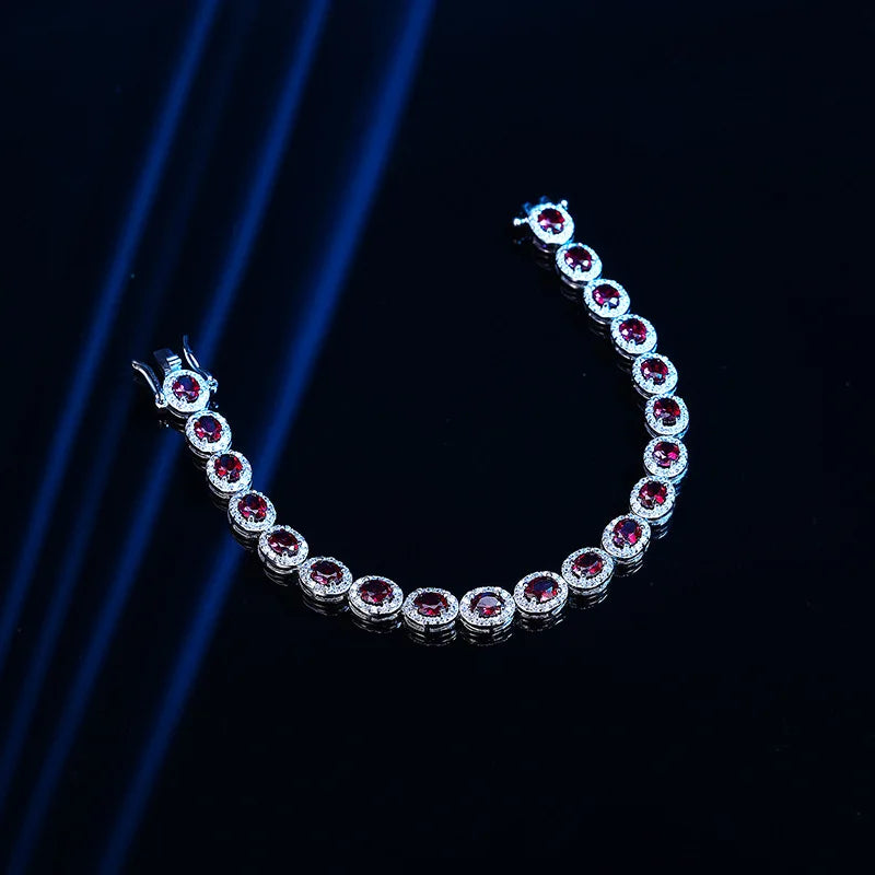 Silver bracelet with red gemstones on a dark background