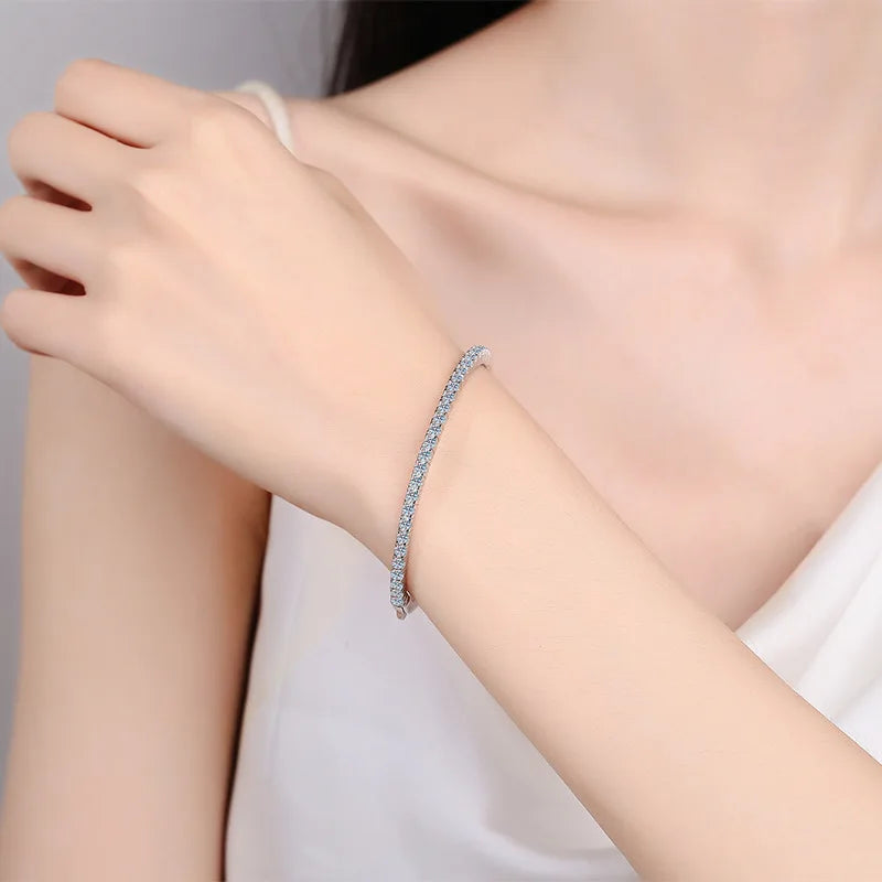 Silver bracelet on a person's wrist with a plain background
