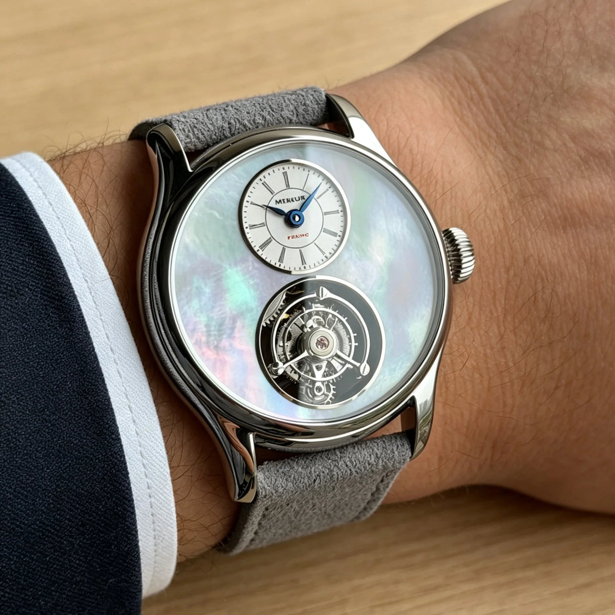 Luxury watch with a detailed face on a wrist against a wooden background