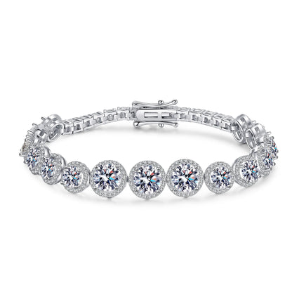 A silver tennis bracelet featuring round-cut clear gemstones in halo settings, displayed on a clean white background.