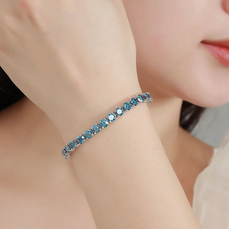 Close-up of a woman wearing a blue gemstone bracelet on her wrist.