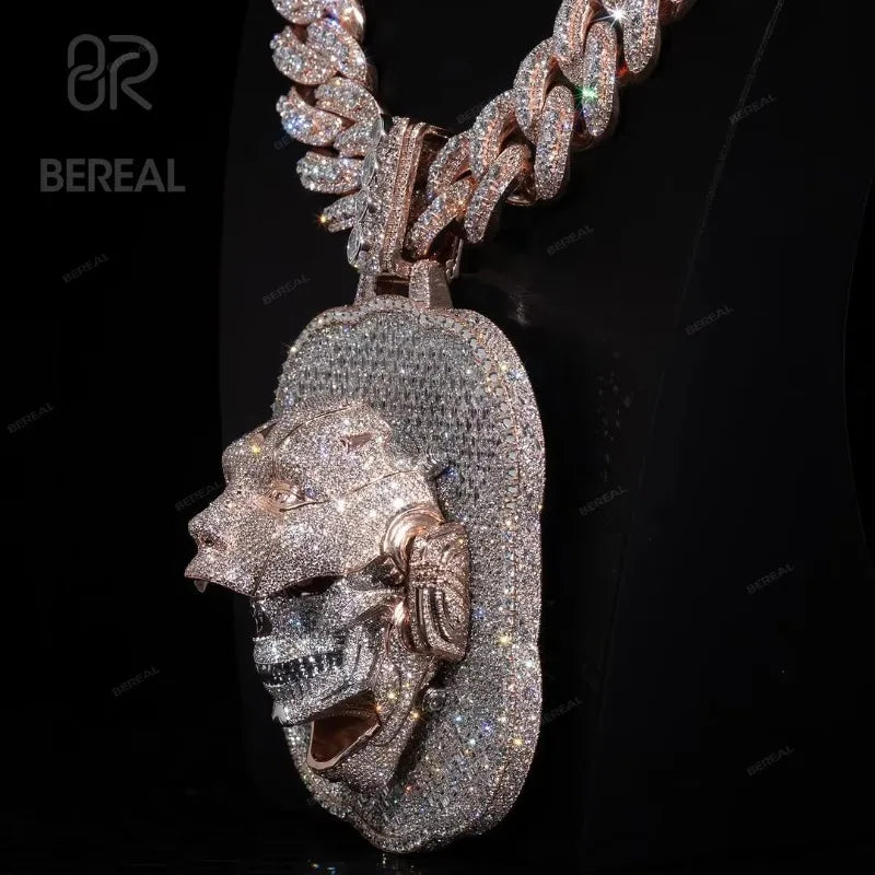 A rose gold chain necklace with a large, heavily embellished lion head pendant covered in sparkling rhinestones, displayed on a black background with a BEREAL watermark.