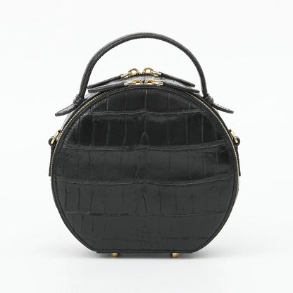 A black crocodile-embossed leather handbag with a top handle and gold-tone hardware, shown against a plain white background.