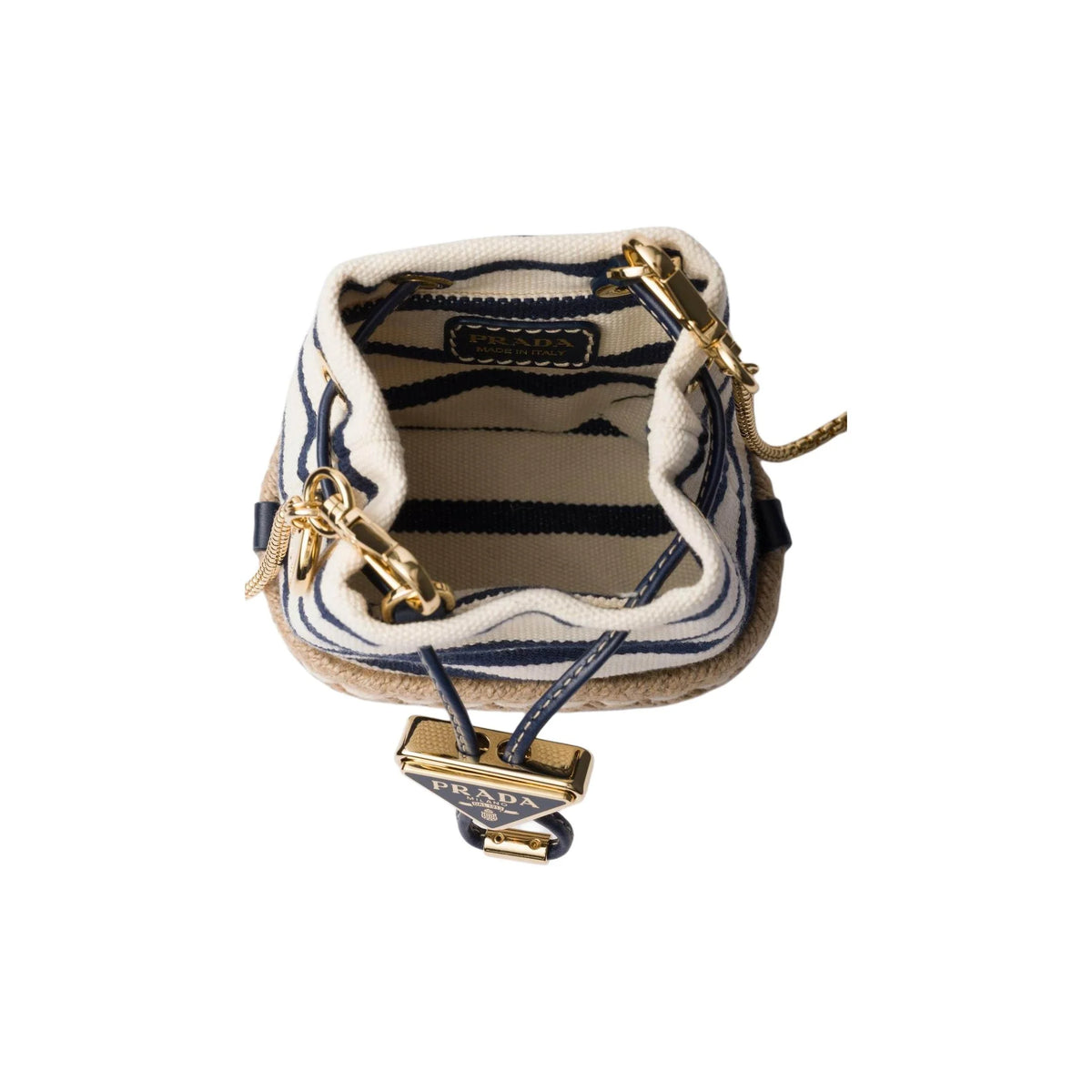 A Prada bucket bag shown from a top-down view, featuring navy blue and cream striped canvas, a beige jute base, gold-tone hardware, and a signature Prada Triomphe charm.