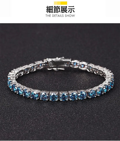 A silver tennis bracelet with round-cut light blue gemstones, displayed on a textured black background. The top of the image features a white banner with Chinese text '新通出版' and English text 'THE DETAILS SHOW'.