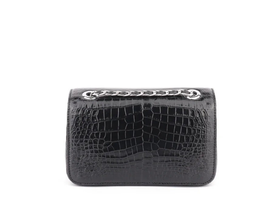 A black crocodile-embossed leather clutch bag with a silver-tone chain detail across the top, shown against a plain white background.
