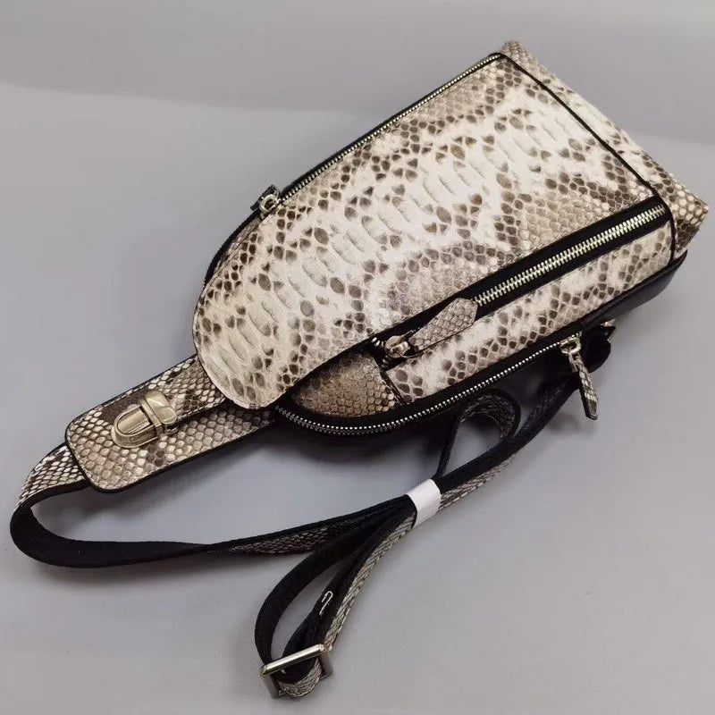 Snake skin patterned bag with black strap on a gray background