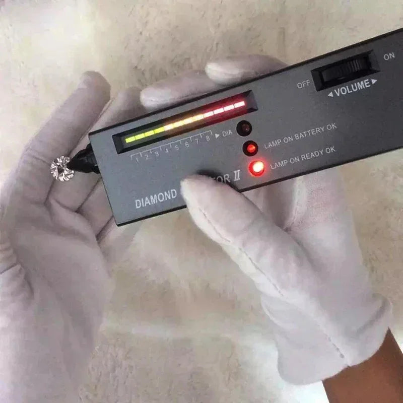 Diamond tester being used on a diamond held by a gloved hand.