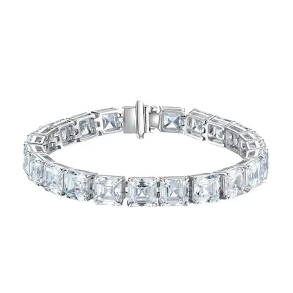A silver tennis bracelet featuring a row of square-cut clear gemstones in a bezel setting, with a polished clasp closure, shown against a plain white background.