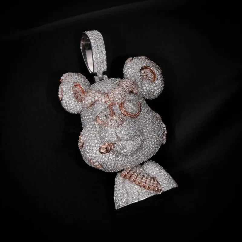A highly detailed, diamond-encrusted pendant shaped like a cartoon bear head with a bow tie, featuring rose gold accents on the ears, eyes, and bow tie, set against a black background.