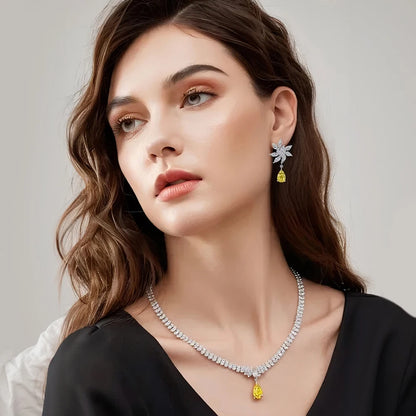 Woman wearing a necklace and earrings with a neutral background