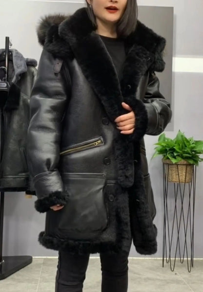 A woman wearing a black shearling-lined aviator-style jacket with a large dark fur collar, standing in a store interior.