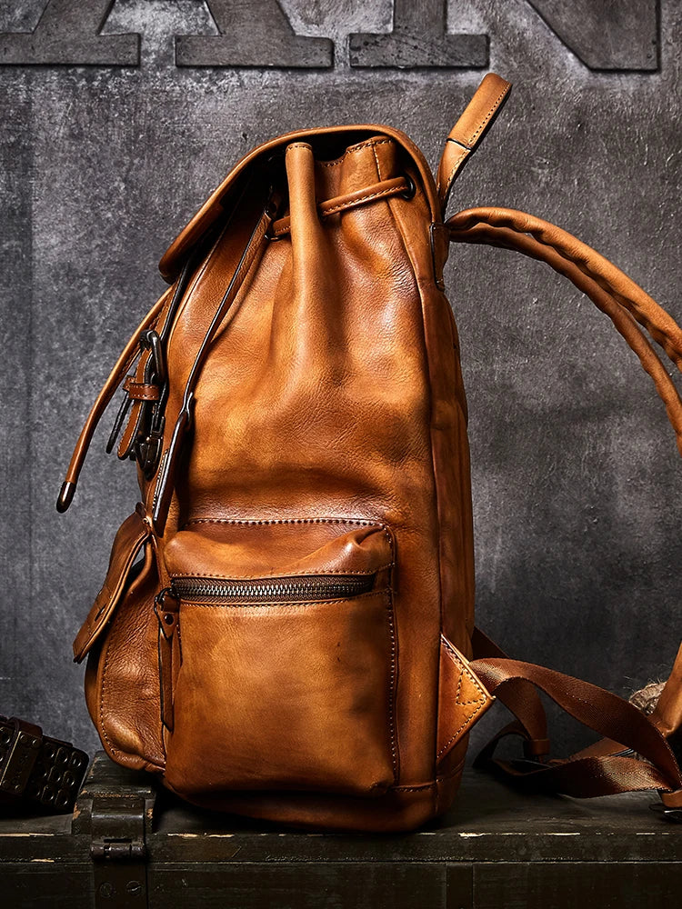 Brown leather backpack on a dark textured background
