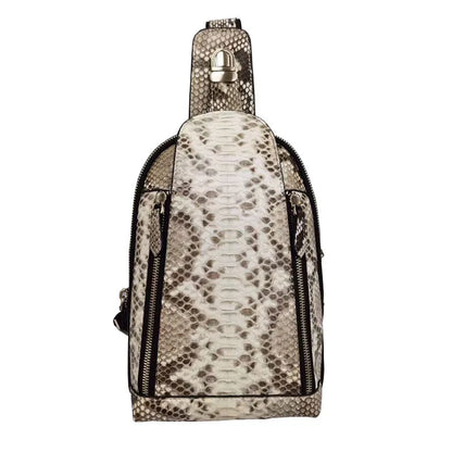 A snakeskin-patterned shoulder bag in beige and brown tones with black zippers and a silver-tone metal clasp on the strap, shown against a plain white background.