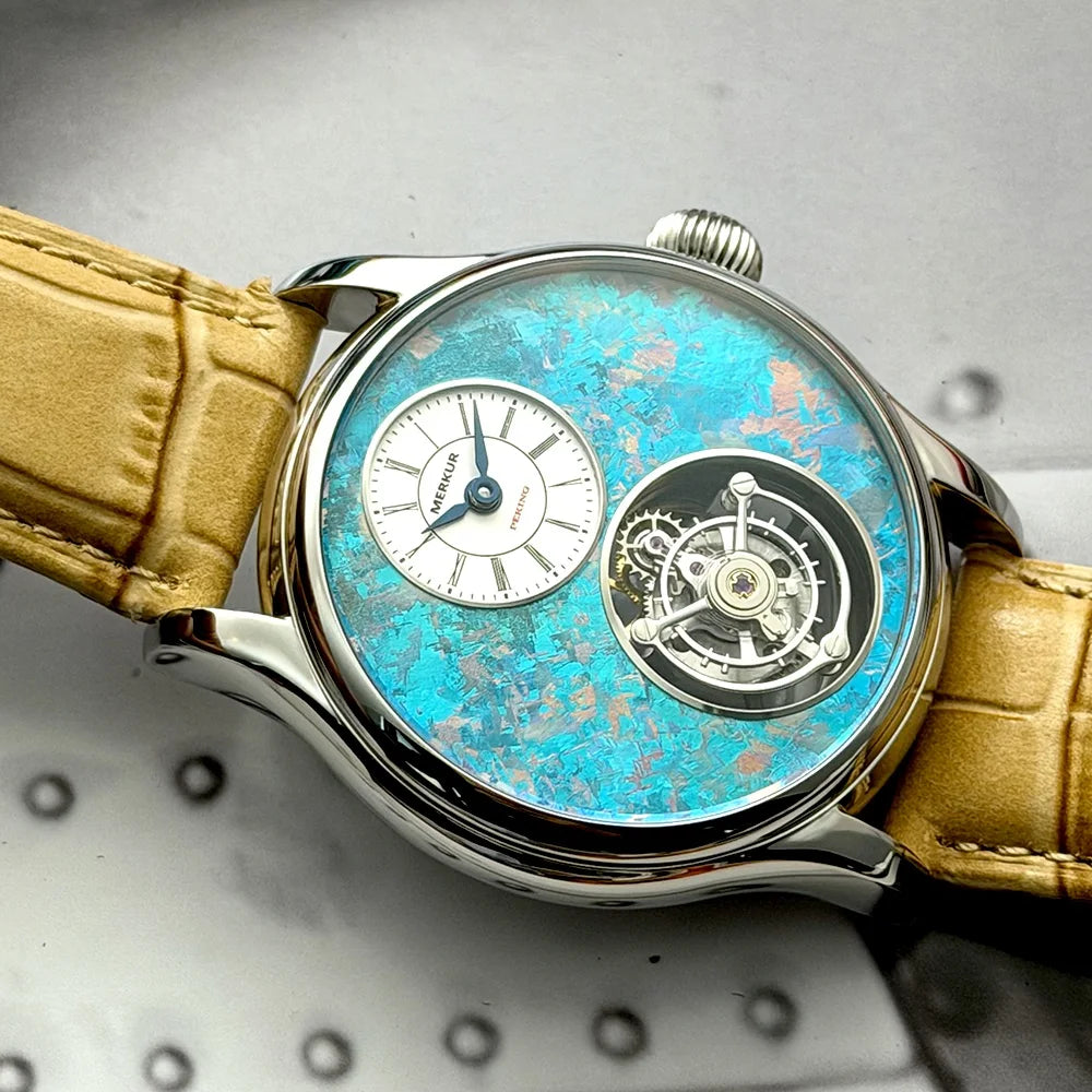 Luxury watch with a blue face and gold strap on a textured surface