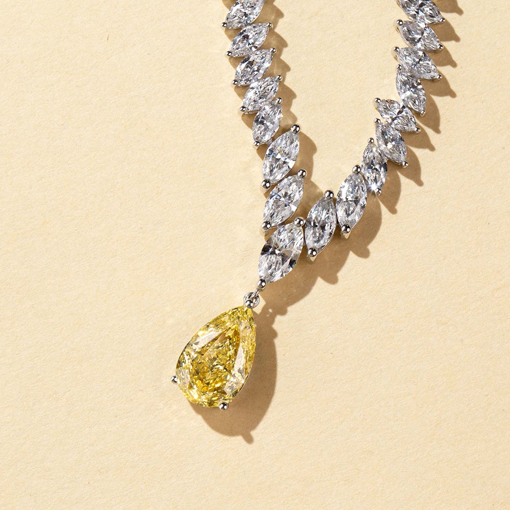 Diamond necklace with a yellow pear-shaped diamond on a beige background