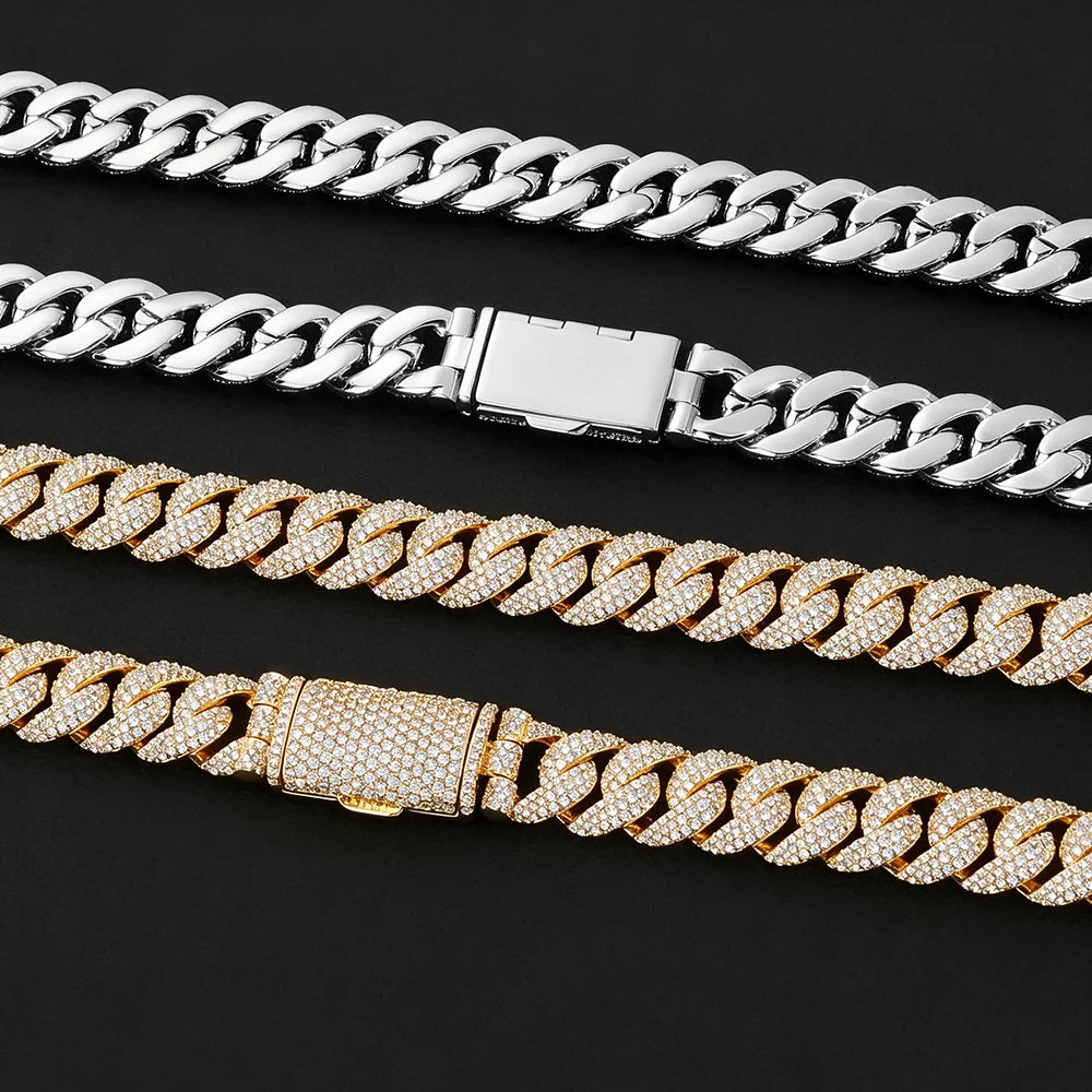 Four Cuban link chain necklaces arranged diagonally on a black background, including two silver-toned and two gold-toned chains, with three of them featuring pavé-set rhinestones.