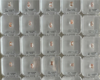 Multiple small diamonds in clear display cases on a grid pattern