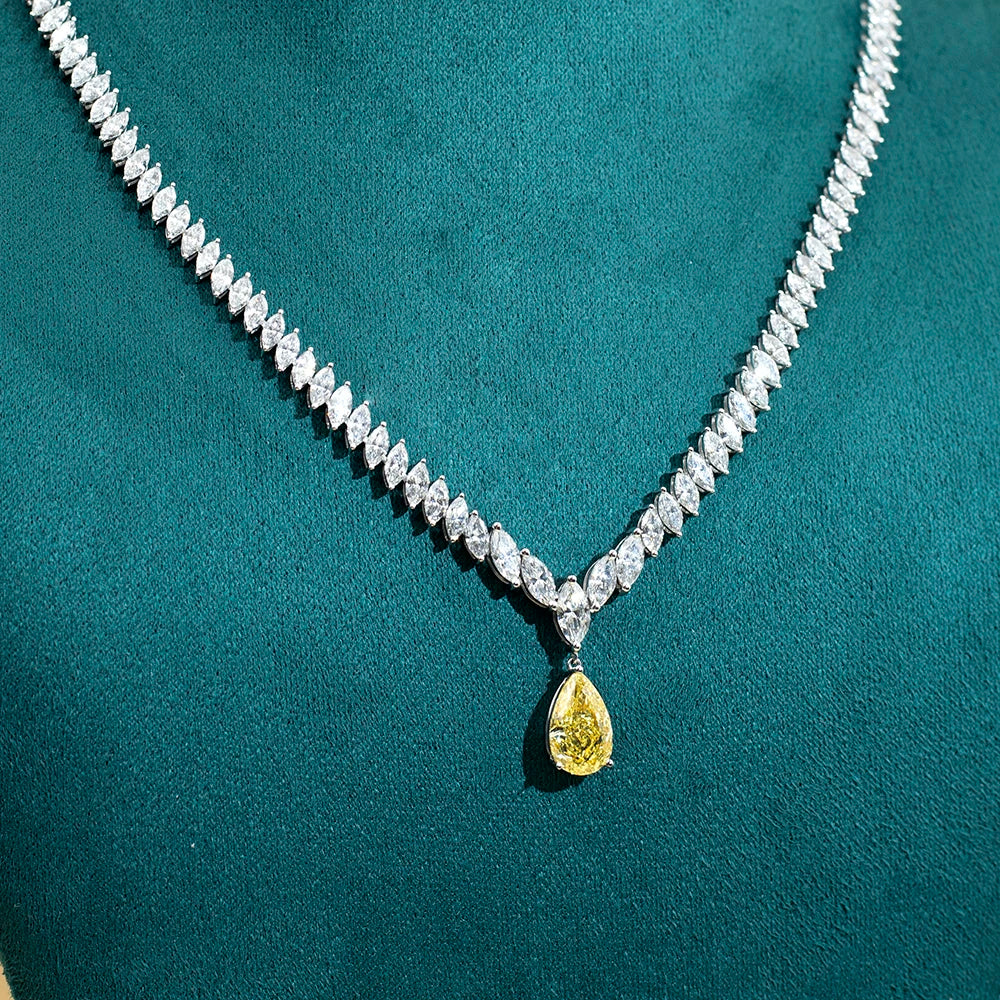 Diamond necklace with a yellow teardrop pendant on a teal background