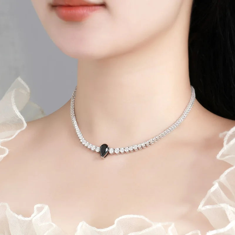 Necklace with a black heart pendant worn by a model against a neutral background