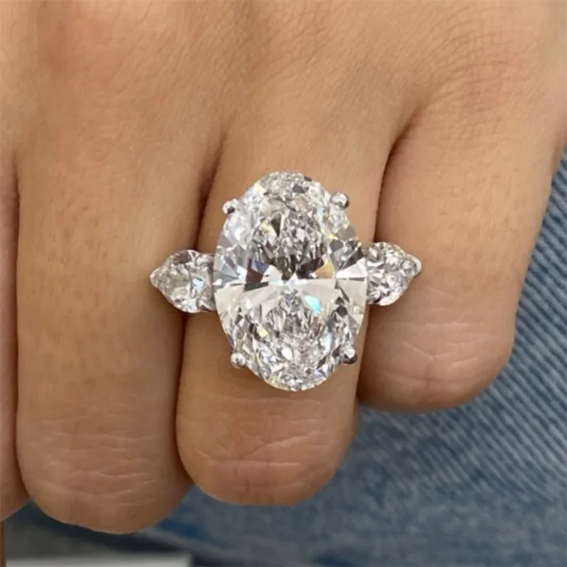 Diamond ring with pear-shaped side stones on a finger