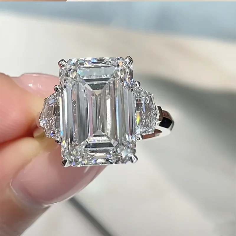 Diamond ring held by a hand with a blurred background