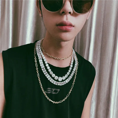 Person wearing multiple necklaces with a neutral background