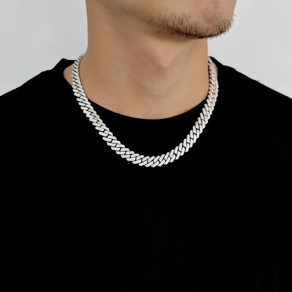 Silver chain necklace worn by a person on a plain background
