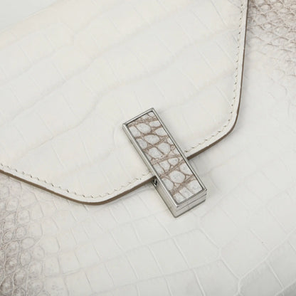A close-up of a white textured leather clutch bag with a silver-toned metal clasp featuring a white and gray crocodile skin pattern.