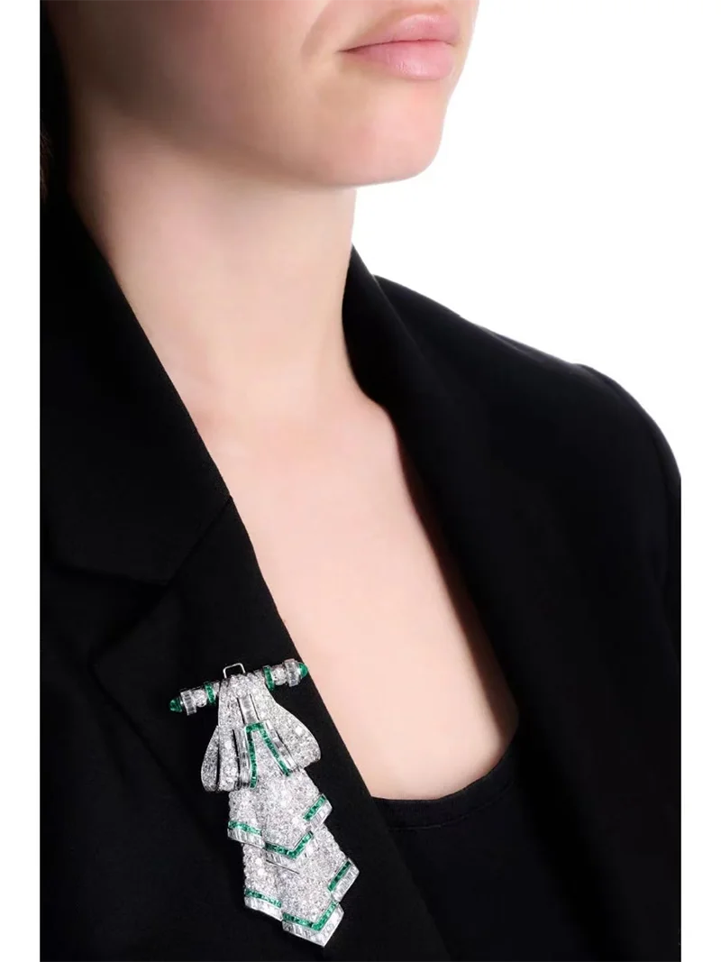 Close-up of a person wearing a black blazer with a decorative brooch.