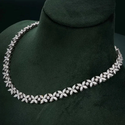 Silver necklace with floral design on a green mannequin bust