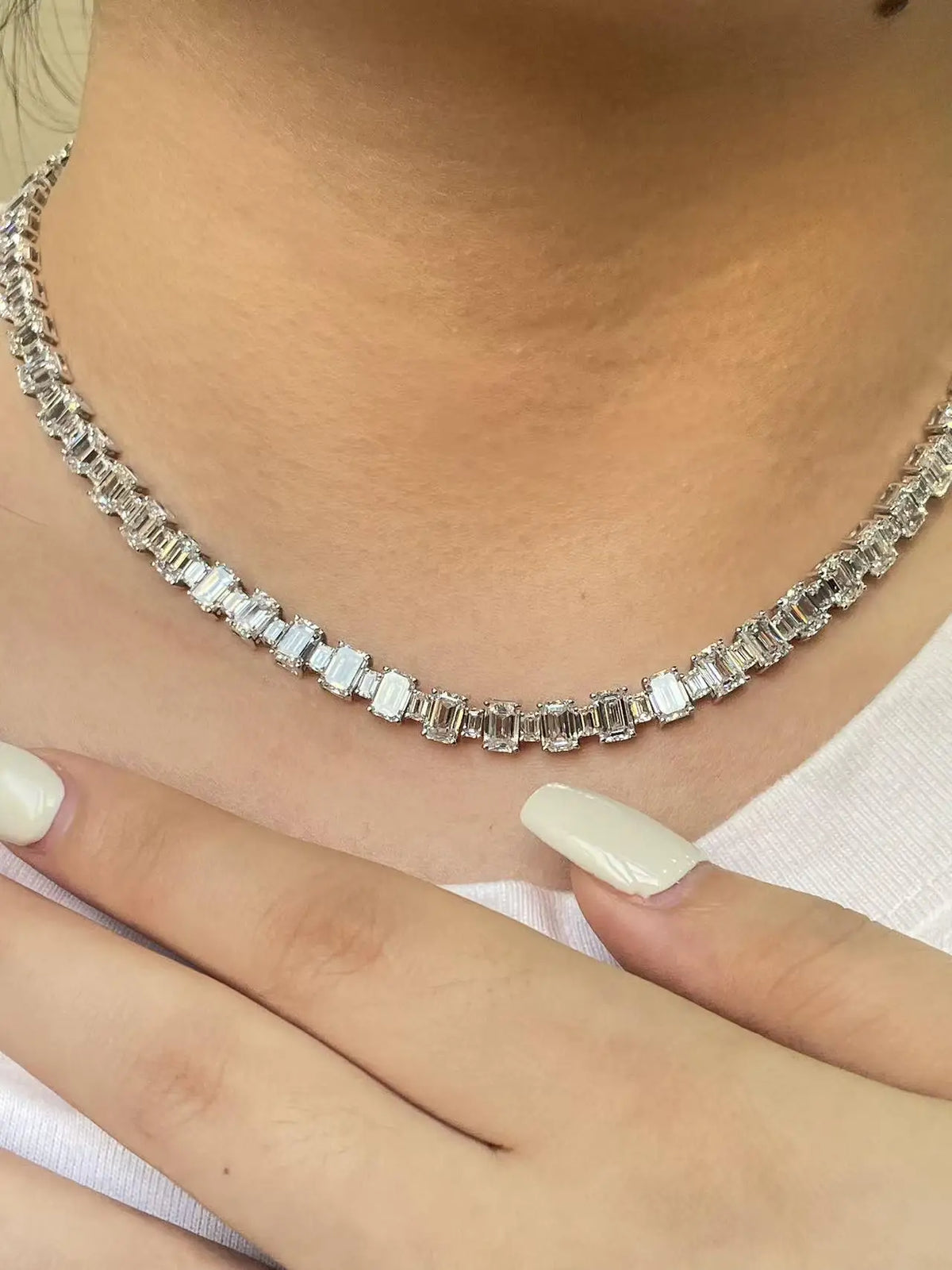 Silver necklace with rectangular stones worn by a person