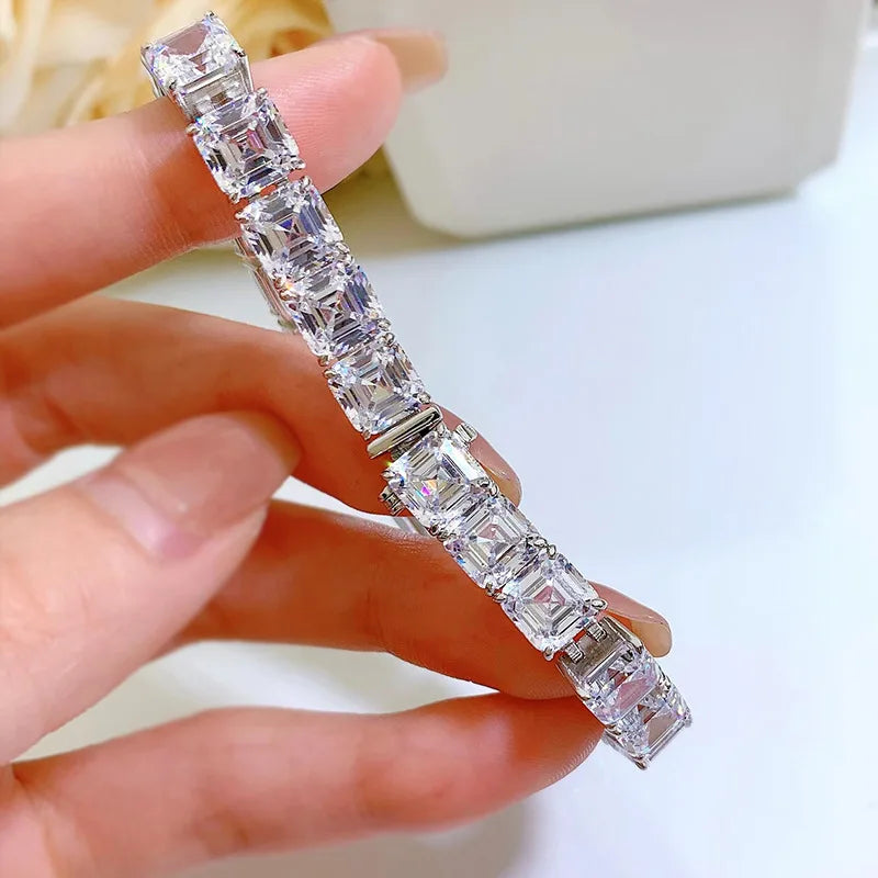Diamond bracelet held by a hand against a blurred background