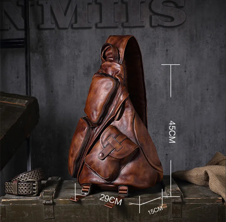 A brown leather sling backpack displayed on a rustic wooden crate against a dark gray textured wall, with overlaid dimension lines showing measurements of 45cm height, 29cm width, and 15cm depth.